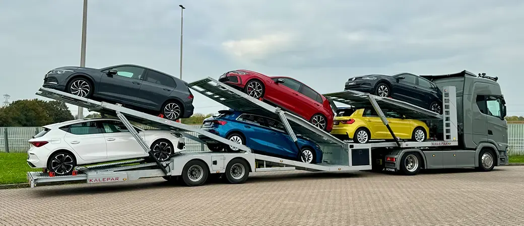Een autotransporter met nieuwe auto's komt aan bij Germany Dealer