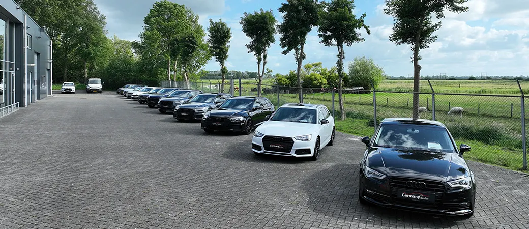 Het buitenterrein van Germany Dealer met een rij auto's