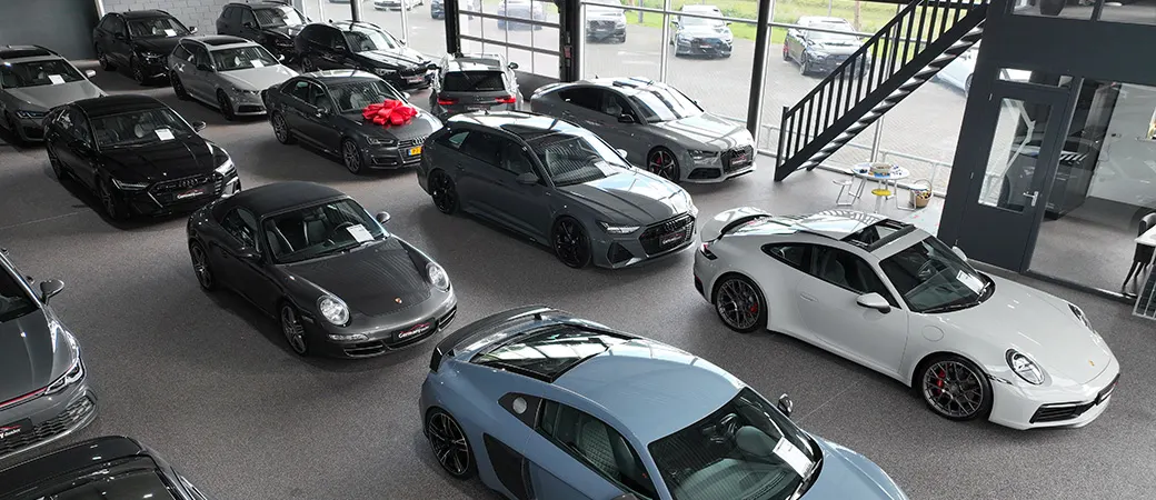 De showroom van bovenaf, met Porsches en Audi's